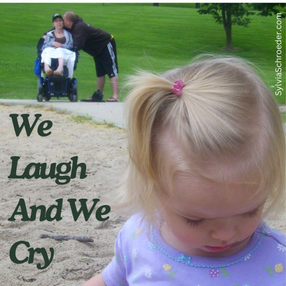 Husband kissing wife in wheelchair while daughter plays