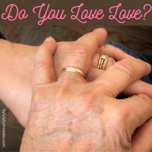 husband's hand on wife's hand showing wedding rings